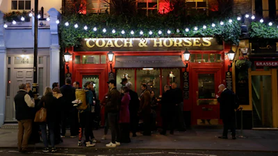 People stand outside the Coach & Horses pub, London, March 17, 2020.