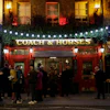 People stand outside the Coach & Horses pub, London, March 17, 2020.