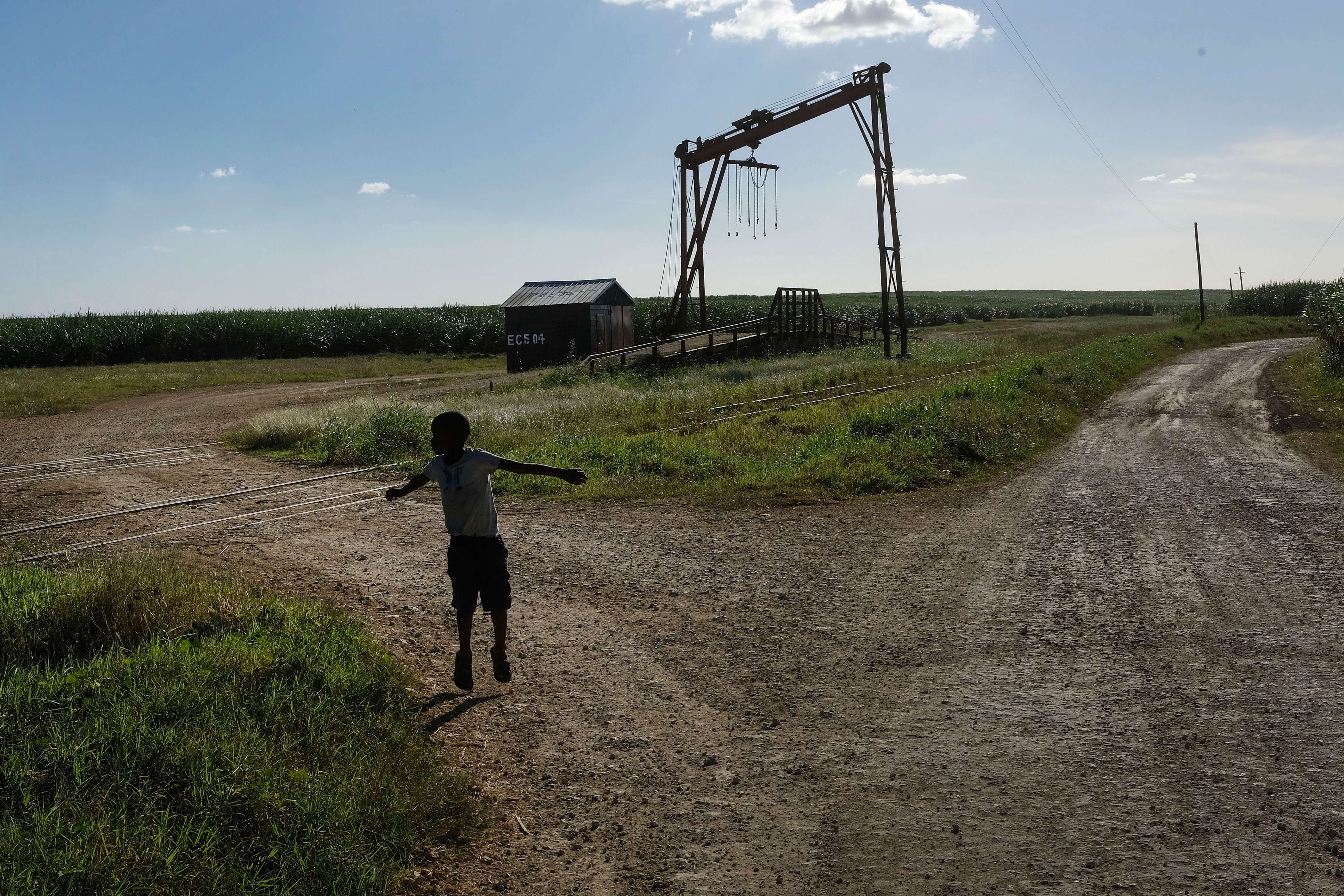 A child plays near a machine where sugar cane is weighed in La Romana, Dominican Republic, Nov. 17, 2021.