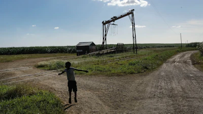 A child plays near a machine where sugar cane is weighed in La Romana, Dominican Republic, Nov. 17, 2021.