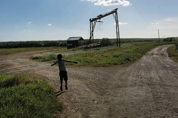 A child plays near a machine where sugar cane is weighed in La Romana, Dominican Republic, Nov. 17, 2021.