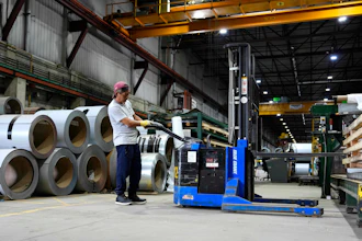 A worker operates a forklift in front of steel coils at Ideal Roofing in Ottawa, Aug. 25, 2026.