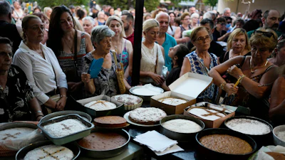 Pilgrims wait in line to have their Fanouropites blessed at the Church of St. Fanourios, Athens, Aug. 26, 2026.