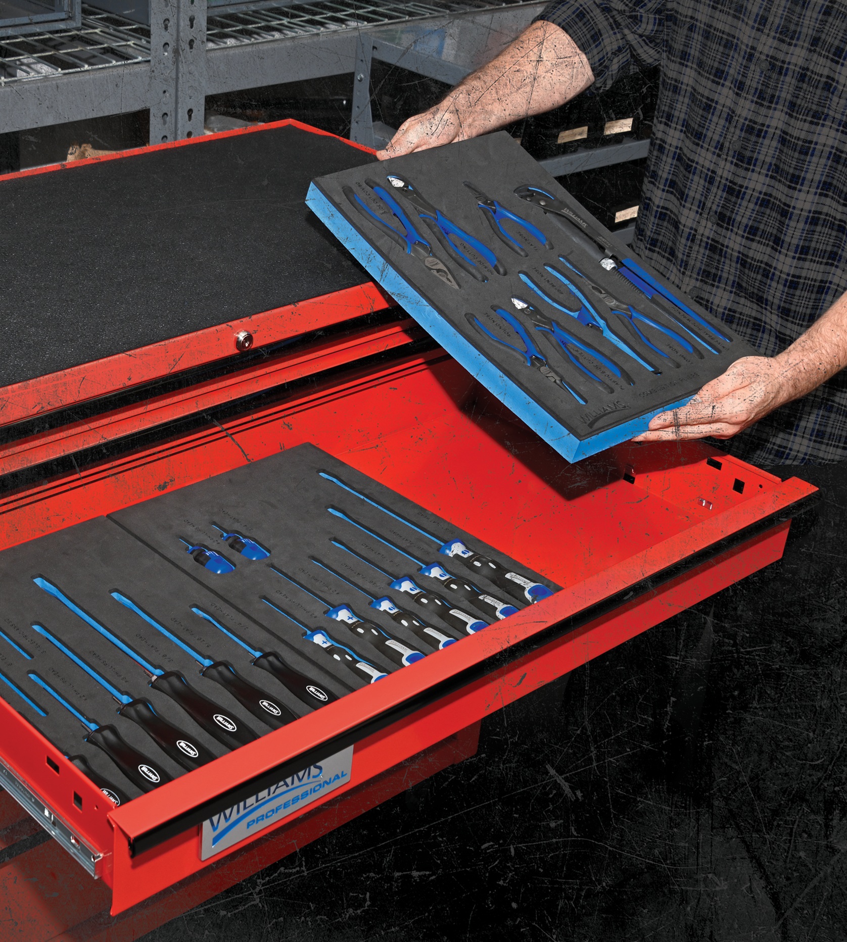 Mechanic organizing blue-handled tools in red Snap-on toolbox with foam inserts