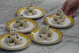 Chef Zhou Tong prepares red bean rolls at Fangshan Restaurant inside Beihai Park, Beijing, July 23, 2026.