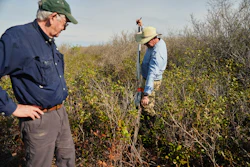 Neal Flanagan, right, a research scientist at Duke University, uses a tool to take a soil sample from a peatland as Curt Richardson, an ecology professor at Duke, observes, May 6, 2026, Belhaven, N.C.