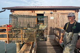 Fisherman Federico Zago poses next to a trap containing blue crabs at his fishing cabin over the Scardovari Lagoon in Italy's Po River Delta, Aug. 21, 2026.