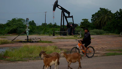 A man rides past an operating oil pumpjack in Cabimas, Venezuela, Aug. 31, 2026.