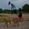 A man rides past an operating oil pumpjack in Cabimas, Venezuela, Aug. 31, 2026.