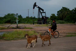 A man rides past an operating oil pumpjack in Cabimas, Venezuela, Aug. 31, 2026.
