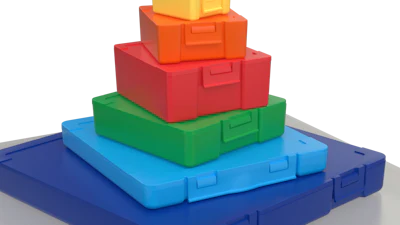 Colorful stacking toy blocks arranged in pyramid formation on gray base platform