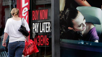 A woman walks by a 'Buy now pay later' sign at a store in Bangalore, India, Sept. 10, 2009.