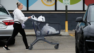 A woman pushes a shopping cart as she leaves a grocery store in Arlington Heights, Ill., Sept. 30, 2026.