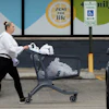 A woman pushes a shopping cart as she leaves a grocery store in Arlington Heights, Ill., Sept. 30, 2026.