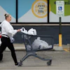 A woman pushes a shopping cart as she leaves a grocery store in Arlington Heights, Ill., Sept. 30, 2026.