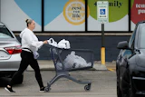 A woman pushes a shopping cart as she leaves a grocery store in Arlington Heights, Ill., Sept. 30, 2026.