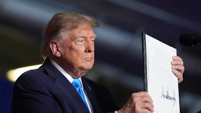 President Donald Trump displays a signed executive order at a campaign rally at the Pinnacle Bank Expo Center, Oct. 5, 2026, Grand Island, Neb.