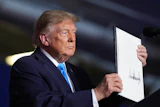 President Donald Trump displays a signed executive order at a campaign rally at the Pinnacle Bank Expo Center, Oct. 5, 2026, Grand Island, Neb.