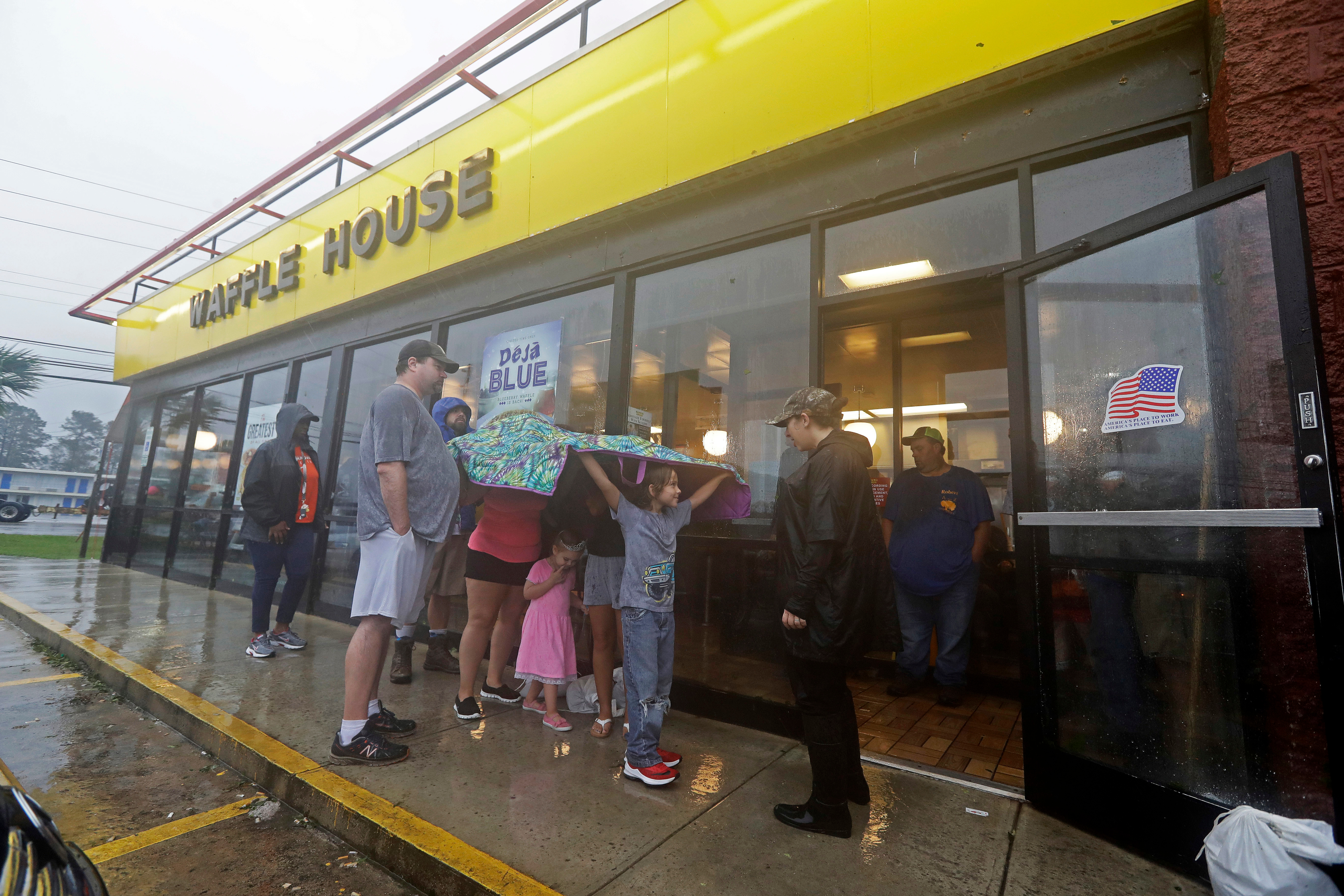 Luke Churchill, left, stands with his wife Mary and their children Katie, Liam and Raighan outside a Waffle House restaurant in Wilmington, N.C., Sept. 16, 2018.
