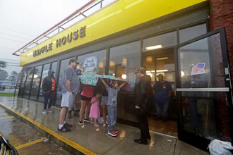 Luke Churchill, left, stands with his wife Mary and their children Katie, Liam and Raighan outside a Waffle House restaurant in Wilmington, N.C., Sept. 16, 2018.
