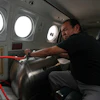 Technician Juan Carlos Diaz operates equipment aboard an aircraft during a cloud-seeding mission, Valle Siria, Honduras, Oct. 14, 2026.