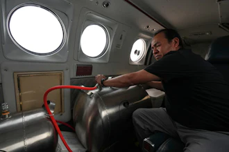 Technician Juan Carlos Diaz operates equipment aboard an aircraft during a cloud-seeding mission, Valle Siria, Honduras, Oct. 14, 2026.