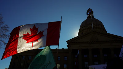 A Canadian flag flies in front of the of the Alberta Legislature during a rally in Edmonton, Oct, 18, 2026.