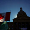 A Canadian flag flies in front of the of the Alberta Legislature during a rally in Edmonton, Oct, 18, 2026.