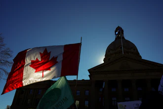 A Canadian flag flies in front of the of the Alberta Legislature during a rally in Edmonton, Oct, 18, 2026.