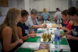 Nuria Isanda, 75, third from left, teaches tourists how to prepare and present traditional Spanish dishes during a cooking workshop at Grandmas Cooking in Barcelona, Oct. 14, 2026.