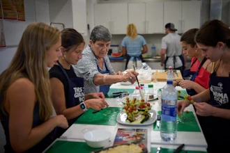 Nuria Isanda, 75, third from left, teaches tourists how to prepare and present traditional Spanish dishes during a cooking workshop at Grandmas Cooking in Barcelona, Oct. 14, 2026.