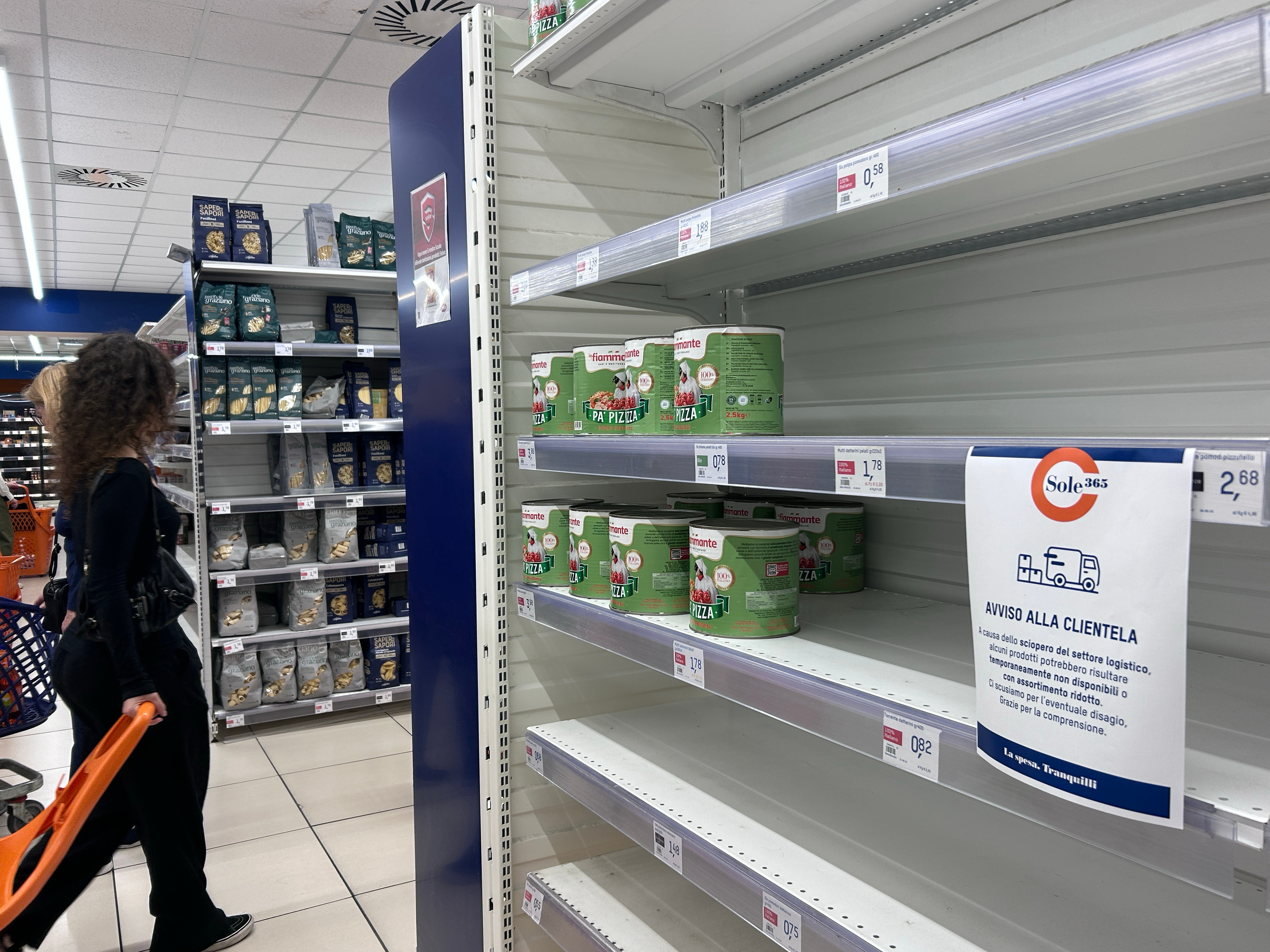 A notice on empty shelves at a supermarket apologizes to customers for the lack of products, Naples, Italy, Oct. 20, 2026.