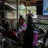 Sara Ramirez, a researcher working for the Association of Saamaka Communities, talks with a group about satellite analysis in Nieuw Aurora, Suriname, Sept. 29, 2026.
