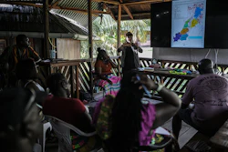 Sara Ramirez, a researcher working for the Association of Saamaka Communities, talks with a group about satellite analysis in Nieuw Aurora, Suriname, Sept. 29, 2026.
