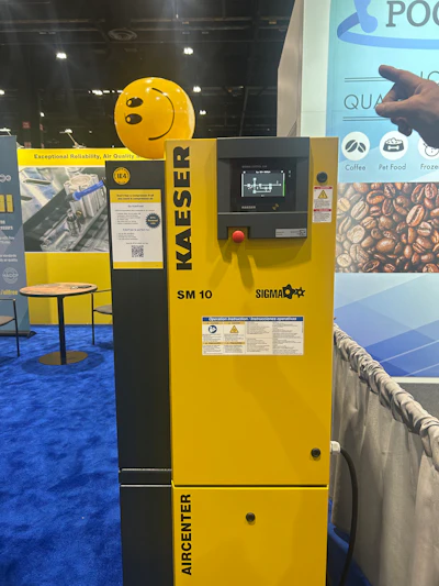 Kaeser SM 10 Sigma air compressor unit displayed at trade show booth with yellow and black branding