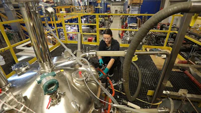 A staff member at the Integrated Bioprocessing Research Laboratory, University of Ilinois Urbana-Champaign, works at the argest precision fermentation tank.