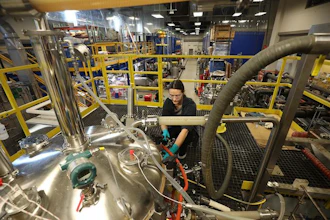 A staff member at the Integrated Bioprocessing Research Laboratory, University of Ilinois Urbana-Champaign, works at the argest precision fermentation tank.